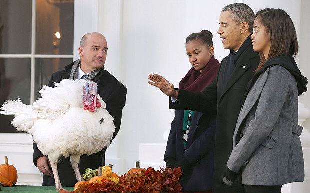 President Obama - watched by his duaghers Sasha and Malia- pardons a lucky turkey